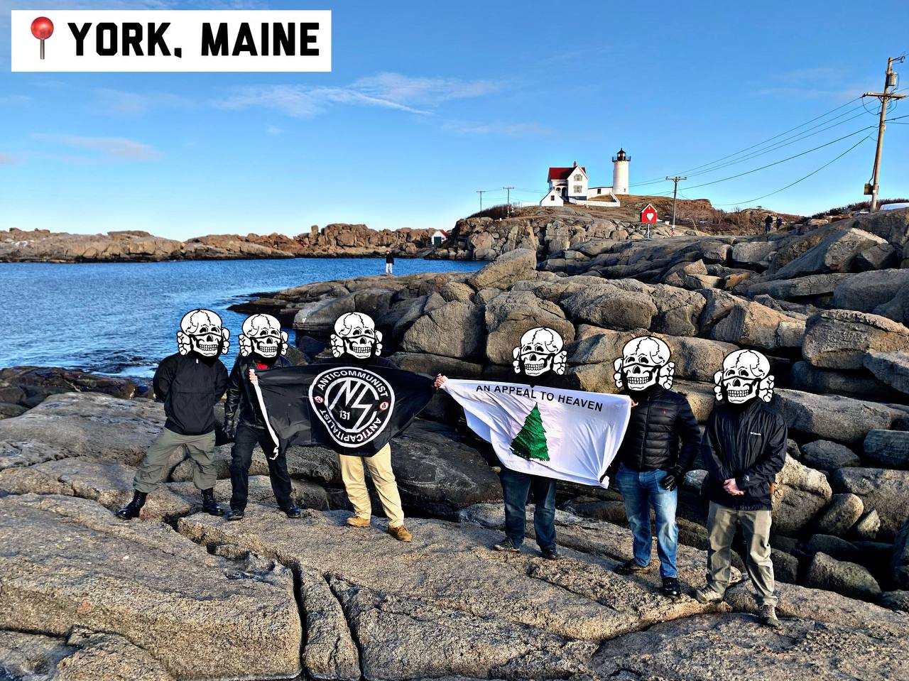 Picture that is location-stamped in York, Maine showing a group of six masked men standing with the NSC 131 flag, the rocky beach and a lighthouse is their backdrop.