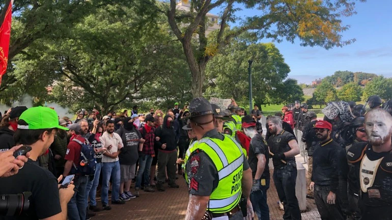white supremacists on the right stand protected by RI police while peaceful counter protesters assemble a few feet away