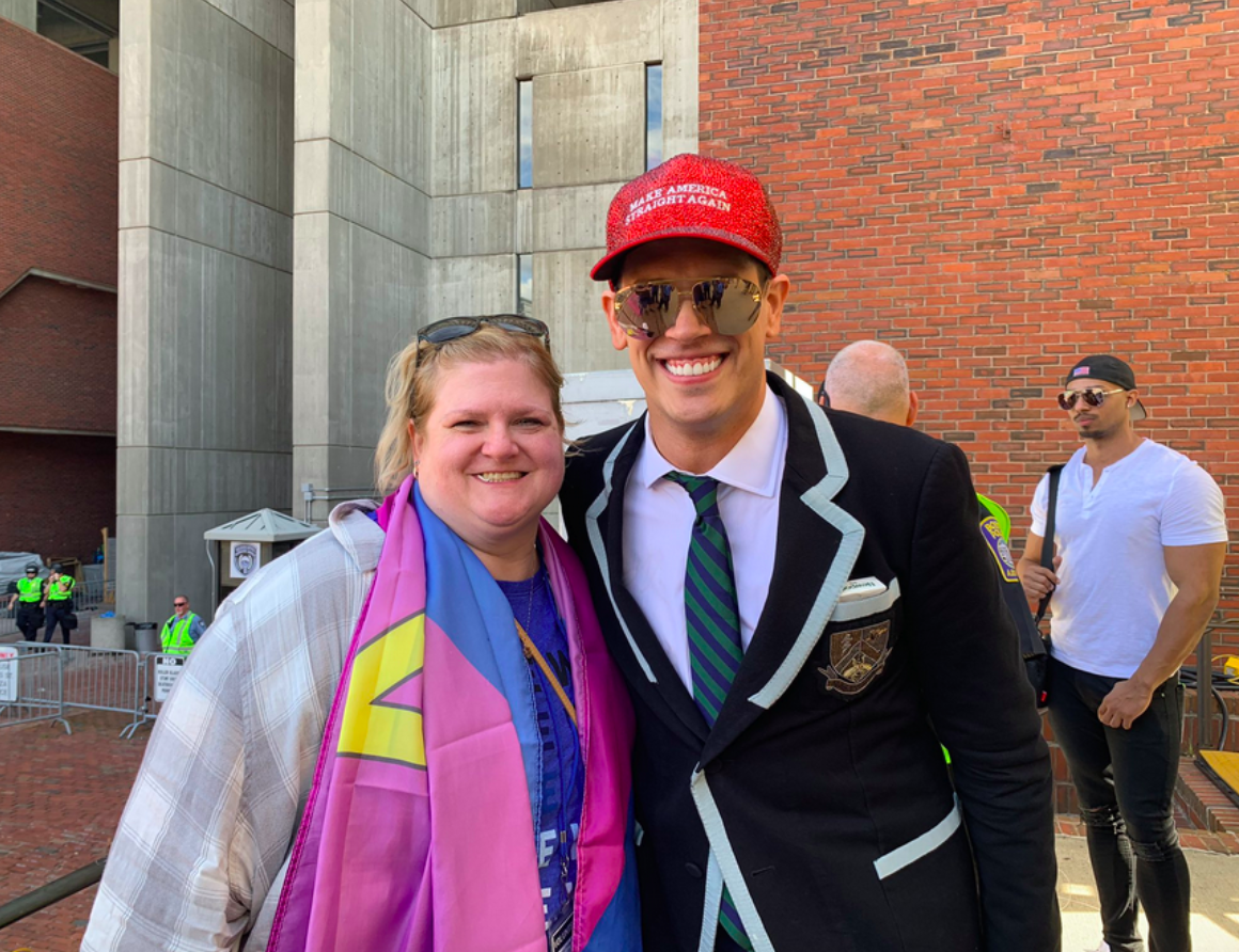 Picture of Tara (a white woman with blonde hair) with Milo Yiannapolous (a tall young white man). Tara has a Straight Pride flag around her neck. Milo is wearing sunglasses and a "Make America Straight Again" hat