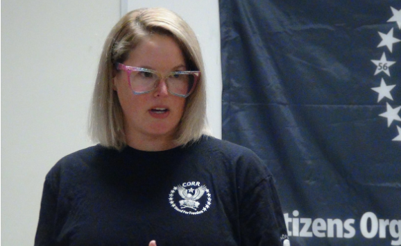 Image of Katie Ferriera-Aubin, she has blond hair cut in a bob, and is wearing a blue shirt. 